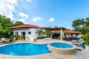 a villa with a swimming pool and a house at Villa Cajuiles 13, Casa de Campo in La Romana