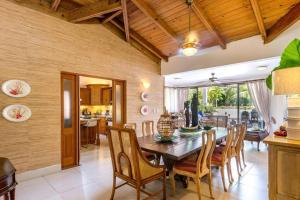 a kitchen and dining room with a wooden table and chairs at Villa Cajuiles 13, Casa de Campo in La Romana