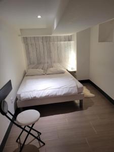 1 dormitorio con 1 cama blanca y 1 silla en Tripiers Duplex, en Colmar