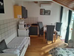 a living room with a kitchen and a dining room at Nyírfa Apartmanház in Zalakaros