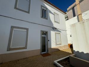 - un bâtiment blanc avec une porte dans une cour dans l'établissement Estoril Escape - Family & Friends Beach Getaway, à Estoril