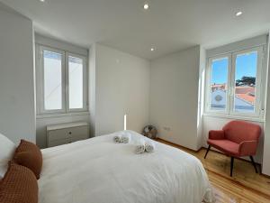 - une chambre blanche avec un lit et une chaise rouge dans l'établissement Estoril Escape - Family & Friends Beach Getaway, à Estoril