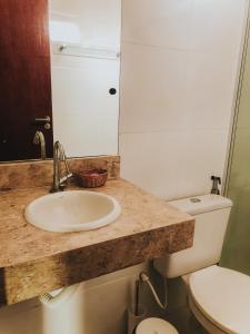 a bathroom with a sink and a toilet at Pousada Rosa do Mar in Gamboa