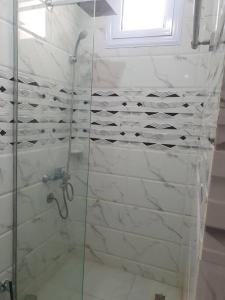 a bathroom with a shower with a glass door at Villa Omar El Sharif Appartement studio n2 in Luxor