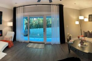 a living room with a sliding glass door with a view of a pool at Charming Gainesville Townhome 2 in Gainesville