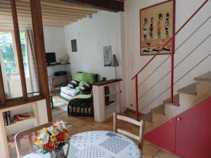 a living room with a staircase and a couch at Halte-jardin du hâvre in Précy-sur-Oise