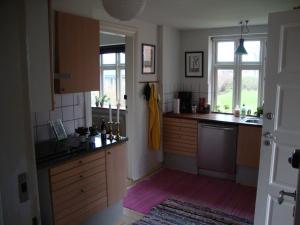 una cocina con armarios de madera y una ventana en Klosterpensionen Annex, en Viborg