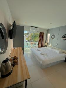 a bedroom with a bed and a table with a television at The Villa Residences Resort in Patong Beach +206 photos