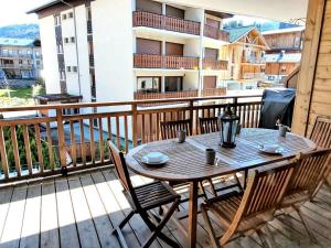 a wooden table and chairs on a balcony at Appartement montagnard 4* cosy, 2 ch, 6 pers - FR-1-598-6 in Les Gets
