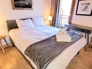 a bed with two teddy bears sitting on top of it at Appartement montagnard 4* cosy, 2 ch, 6 pers - FR-1-598-6 in Les Gets