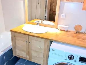 a bathroom with a sink and a washing machine at Appartement montagnard 4* cosy, 2 ch, 6 pers - FR-1-598-6 in Les Gets