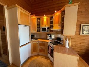 a kitchen with wooden cabinets and a white refrigerator at Rokuan Unelma in Rokua