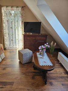 a living room with a table and a tv at Vila Mažoji apartamentai in Palanga