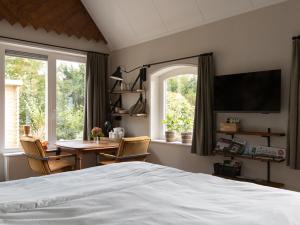 a bedroom with a bed and a table with chairs at B&B De Pastorie in Harfsen
