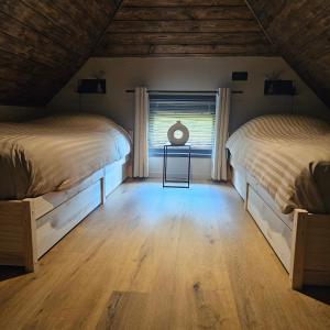 two beds in a room with a window at MOI -Magnifiek Overnachten In- Meppen in Meppen