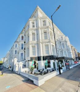 a large white building on the corner of a street at Carlton Court Hotel Eastbourne in Eastbourne