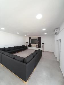 a living room with a black couch and a flat screen tv at Espectacular Casa Quinta en Riachuelo Cts in Laguna Brava