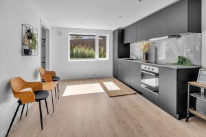 a kitchen with black cabinets and a table and chairs at Paradis på Sørlandet 3 in Kristiansand