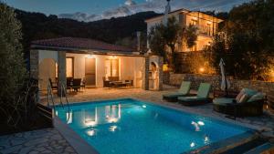 a villa with a swimming pool in front of a house at Skiathos Island Villas in Skiathos