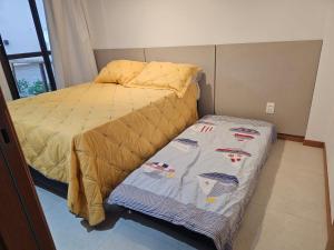 a bed with a yellow bedspread and a small bedskirts at Village Térreo Acqua Guarajuba in Guarajuba +12 photos
