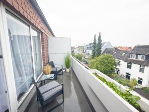an apartment balcony with two chairs and a window at ImmoStay Waterfront Apartments - Balkon über Bremen & Parking in Bremen