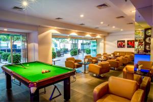 a billiard room with a pool table and chairs at Radha Regent Electronic City in Bangalore