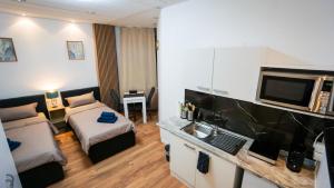 a hotel room with two beds and a television at GLOW Apartment in Magdeburg