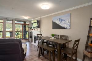 a living room with a dining room table with chairs at 2BR - Located in beautifully acclaimed Nicklaus North Golf Clubhouse in Whistler
