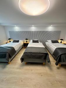 a bedroom with two beds and a large ceiling at Apartamenty Oracka Przystań Solna 1 in Bochnia +7 photos