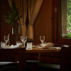 翁根Hotel Alpenrose Wengen - a family affair since 1881的一张木桌,上面放有酒杯