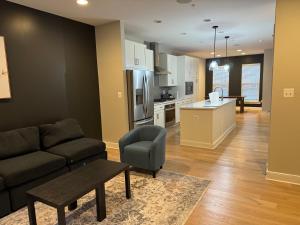 a living room with a couch and a table and a kitchen at LUX Entire House 4BR in DC - Private Garage in Washington