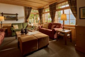 翁根Hotel Alpenrose Wengen - a family affair since 1881的客厅配有两张沙发和一张桌子