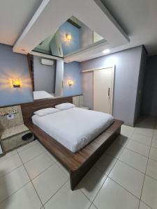 a bedroom with a large bed with white sheets at Velit Prime Motel in Erechim