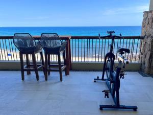 una bicicletta e sedie su un balcone con vista sulla spiaggia di Beachfront 2BD -Ocenview Terrace - Infinity Pool a San José del Cabo