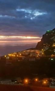 a view of a city at night with a mountain at Paraíso Pico da Torre in Câmara de Lobos