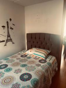 a bedroom with a bed with a quilt and the eiffel tower at La casita in Bogotá