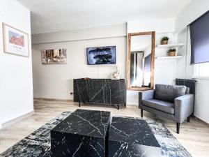 a living room with a black marble coffee table and a chair at The Olive Loft in Vigo