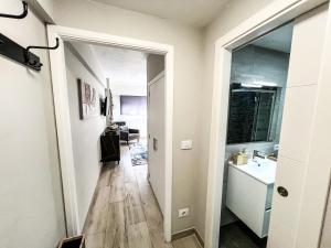 a hallway leading to a bathroom with a sink and a mirror at The Olive Loft in Vigo