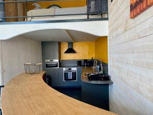 eine Küche mit einem Loft mit Spüle und Herd in der Unterkunft Le petit Casino, insolite et vue mer in Ault