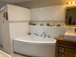 ein weißes Badezimmer mit Badewanne und Waschbecken in der Unterkunft Notre maison de famille, la maison de shaoni in Saint-Romans + 27 Fotos