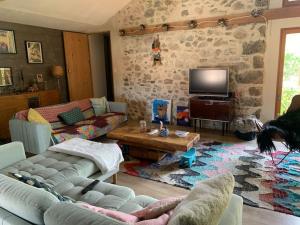a living room with a couch and a tv at Notre maison de famille, la maison de shaoni in Saint-Romans