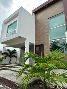 une maison avec des palmiers devant dans l'établissement Casa Lomas de la rioja climatizada y con wifi para hasta 10 personas, à Guadalupe