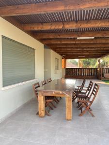 a wooden table and chairs on a patio at וילת שליו במושב in Pa‘ame Tashaz