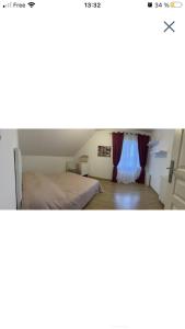 un dormitorio con una cama y una ventana en Maison 5mn gare sncf, en Saint-Doulchard