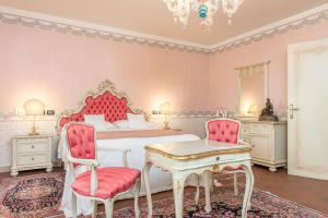 a hotel room with a bed, table and chairs at Duchessa Isabella Hotel & SPA in Ferrara