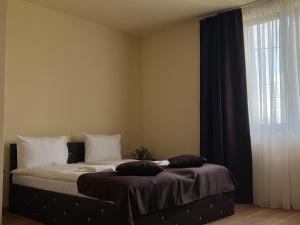 a bed in a room with a window and a bedskirtspectspectspectspects at Pensiunea 82 in Nădlac