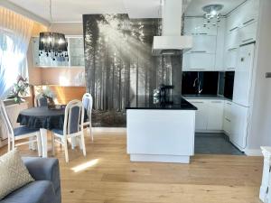 a kitchen and dining room with white cabinets and a table at Apartament La Bella klimatyzacja, garaż podziemny, Fv in Suwałki