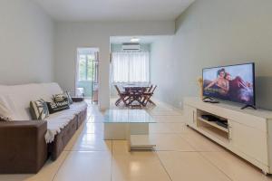 Una sala de estar con un sofá y un televisor de pantalla plana. en 3Hab Conforto: 100m de la Playa Copacabana-Ipanema, en Río de Janeiro