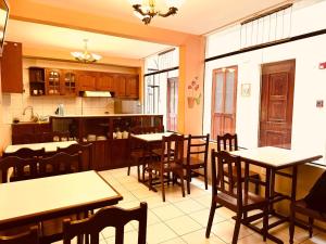 a restaurant with tables and chairs and a kitchen at Hotel Los Angeles in Arequipa