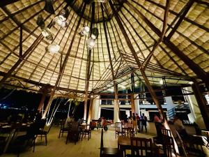a large building with tables and chairs under a large ceiling at Hotel Maya Internacional in Flores